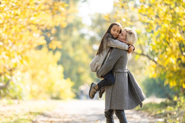 Mom with her daughter during autumn