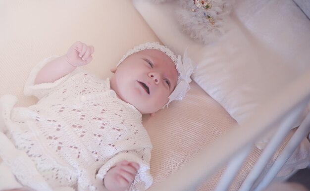 Mom with a newborn baby in her arms. The girl is holding a baby in front of the window. Newborn on mother hands.