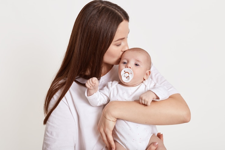 Photo mom with newborn baby posing against light