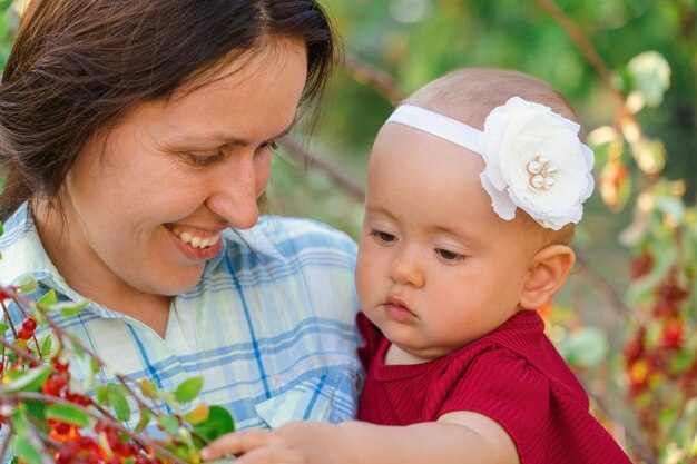 Foto mamma con una figlia appena nata in braccio nel parco