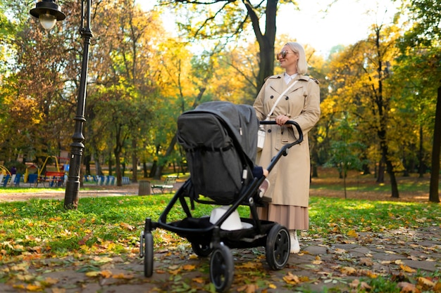 Mom with stroller walks in the park