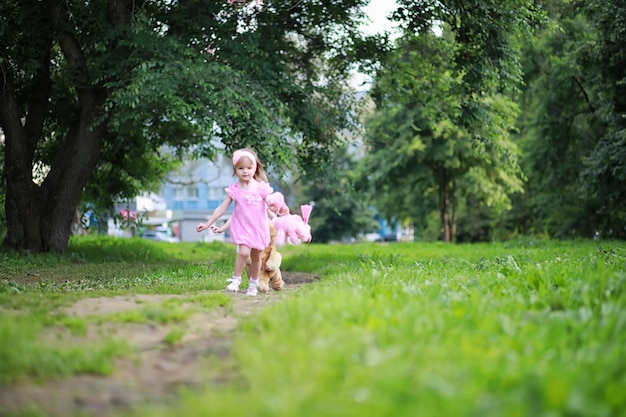 公園を散歩するために2人の娘の双子を持つお母さん