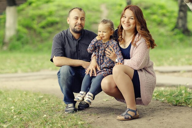 Photo mom and young daughter and dad, a young family on a walk in the park in summer