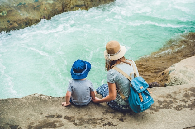 Mom and young son sitting on rocks