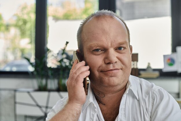 Момент сосредоточения человека на телефонном звонке в современном офисе