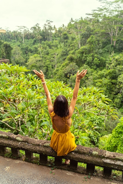 Moment of happiness. Young woman looking forward at jungles while enjoying her vacation in tropics