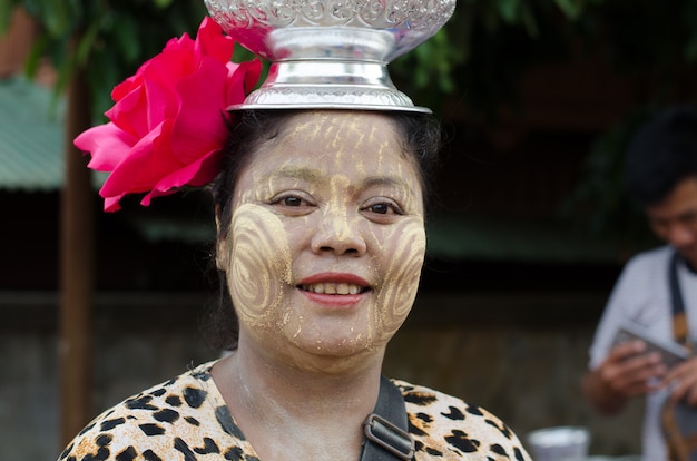 Mon woman carries pots on her head in Sangklaburi, Kanchanaburi, Thailand