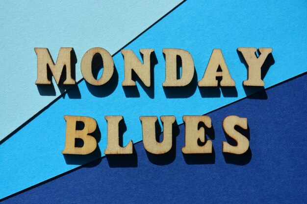 Monday Blues words in wooden alphabet letters isolated on blue background