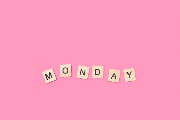 Monday write with wooden letter cubes on a pink background