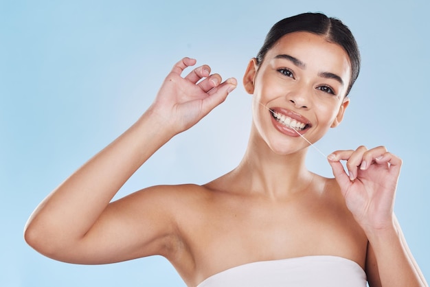 Mondelinge tandheelkundige en flossen vrouw tanden poetsen in een studio blauwe achtergrond mockup Jong model met witte of perfecte glimlach schone mond of tandvlees portret voor hygiëne gezondheidszorg en tandheelkunde mock up