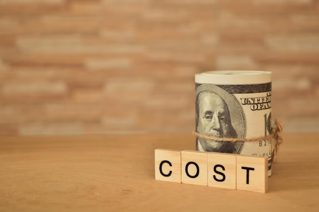 お金の紙幣とテキスト付きの四角い文字 COST