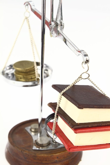 Money and books on balance scale