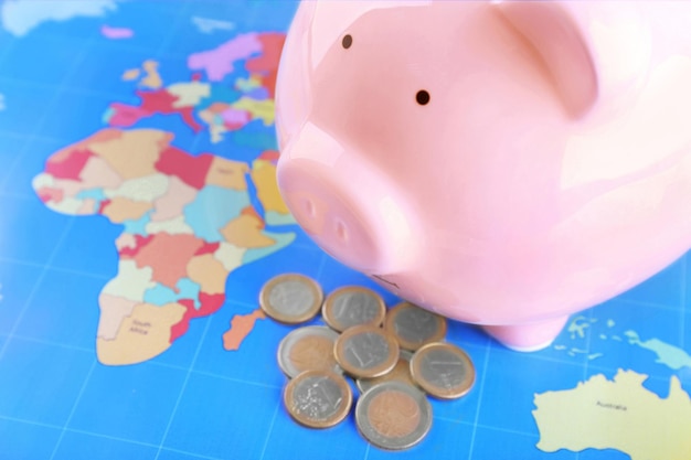 Money box pig on world map background