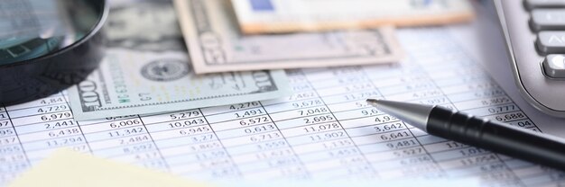 Money and calculator lying on table with numbers closeup