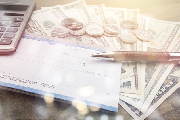 Money and checkbook with pen, calculator on table