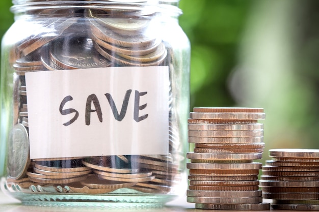 Money coin in glass jar with SAVE text