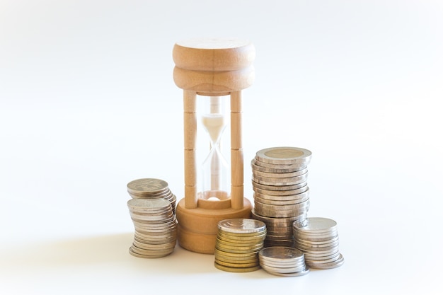 Money coin and hourglass for business earning time and finance concept