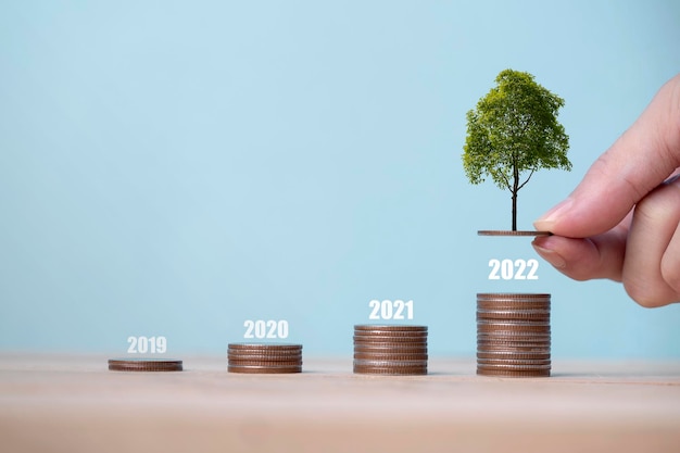 Растущий граф денежной монеты и дерево, растущее на куче денег Идея финансирования бизнеса и экономии денег, инвестиции и растущее денежное дерево, растущее на монетах