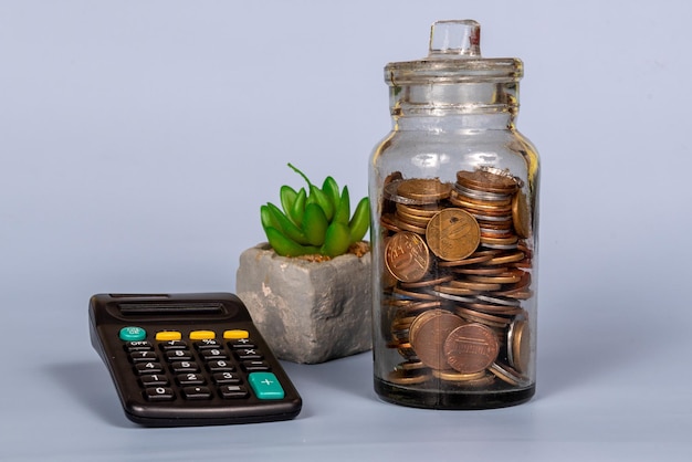 Деньги концепция роста финансового бизнеса монеты в стеклянной банке с калькулятором
