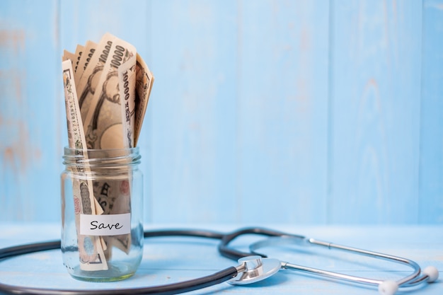 Photo money glass jar and cardiology stethoscope