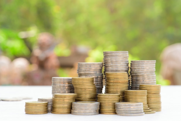 Money Gold coin stack growing graph with green bokeh background