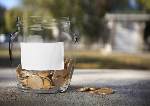 Money Jar with coins on light background