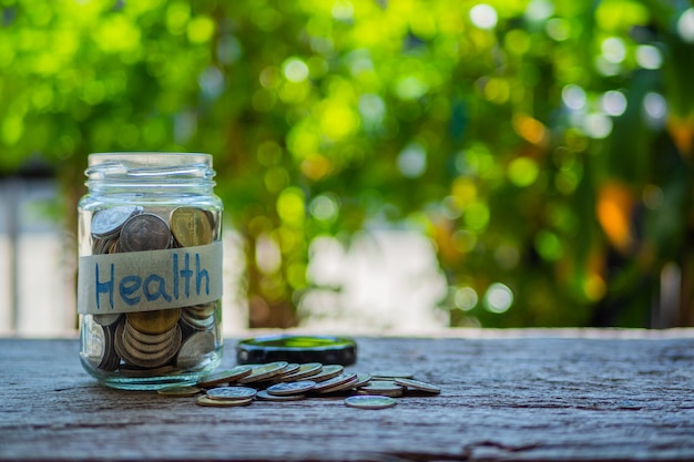 Photo money jar with coins on wood table, health concept