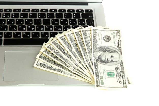 Money on laptop isolated on white