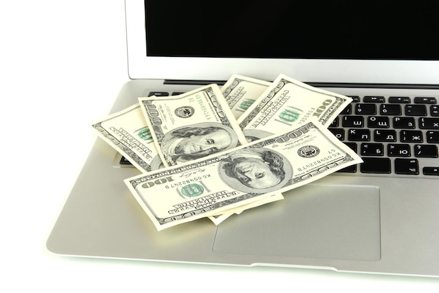 Money on laptop isolated on white