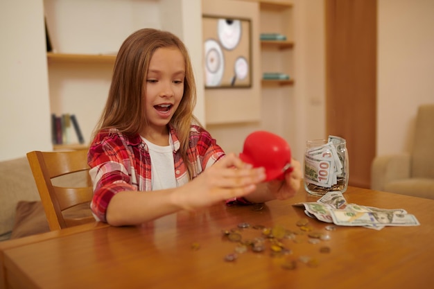 Money. A long-haired cute girl sitting at the table and counting money