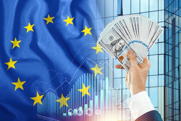 Money in a man's hand against the background of the EU flag