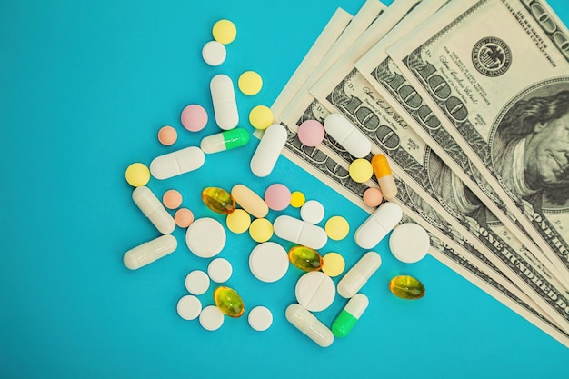 Photo money pills medicine pills on dollar bills on a blue background covid coronavirus pills are in one