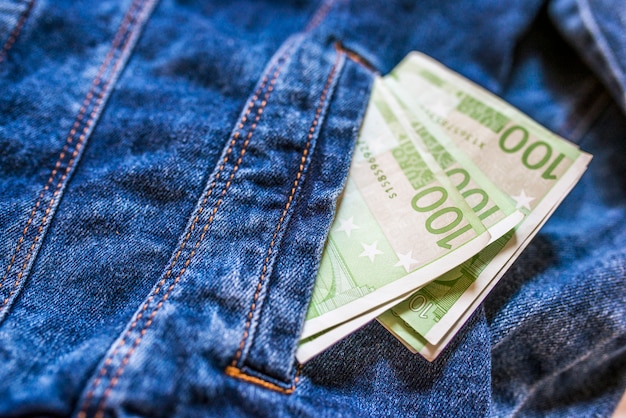 Money in the pocket. Close-up of one hundred Euro banknote in jeans pocket.