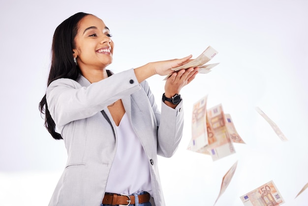 Money rain and a woman lottery winner in studio on a white background in celebration of a bonus or promotion Cash finance and payment with a happy young female excited about investment growth