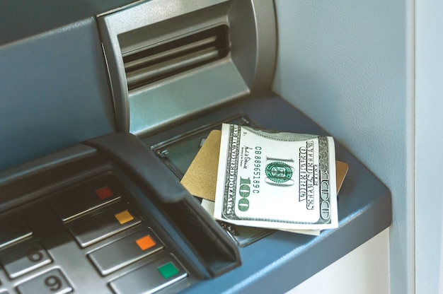 Money with a bank card is on the ATM.