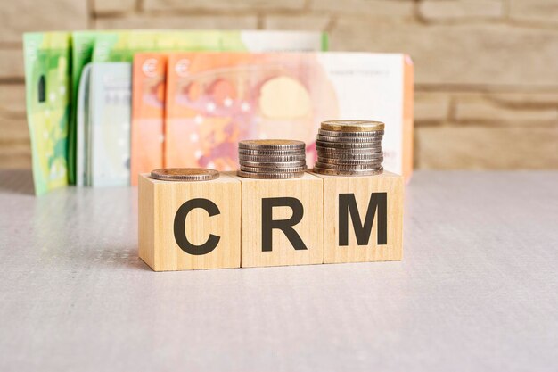 деньги и деревянные кубики с текстом CRM или Customer Relationship Management концепция копирования пространства