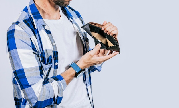 Moneyless frustrated person concept Sad man showing an empty wallet Sad person showing an empty wallet Man with financial problems showing empty wallet