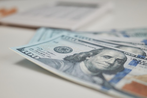 Фото Экономия денег организация долларовых купюр в бизнесе стодолларовые купюры на столе с карандашом и калькулятором на фоне американских валютных моделей