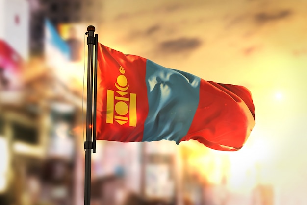 Mongolia Flag Against City Blurred Background At Sunrise Backlight