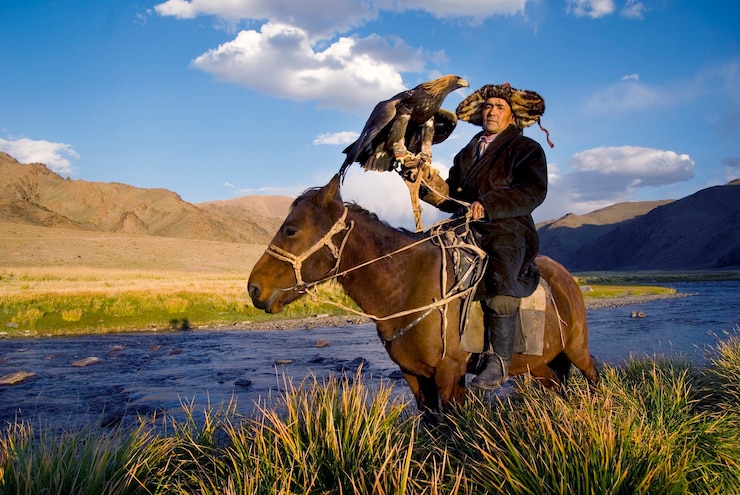 Photo mongolian man on a horse with an eagle