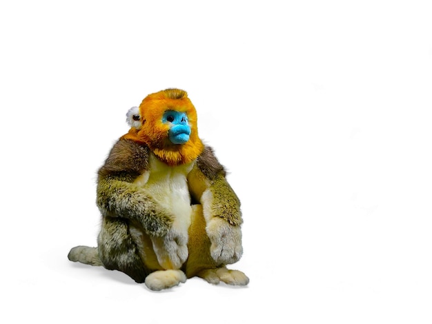 A monkey Doll with a blue nose sits on a white background