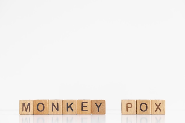 Monkey pox woord is geschreven op houten kubussen op een witte achtergrond Close-up van houten elementen