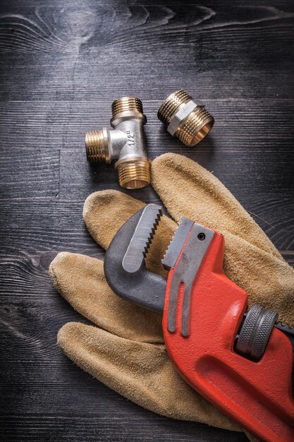 Monkey wrench brass plumbing fittings leather protective gloves construction concept