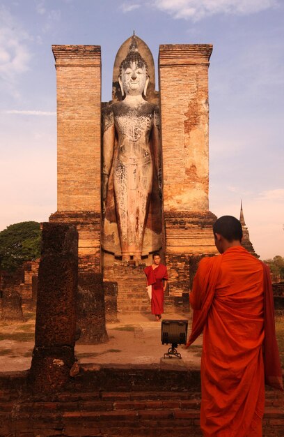 Foto mongi contro la statua di buddha al tempio