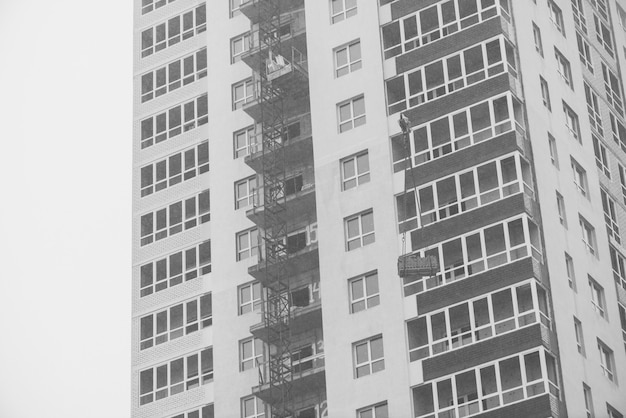 Monochrome concept of apartment building under construction close-up.