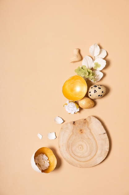 Monochrome flat lay Easter eggs composition with wooden podium Easter still life golden beige