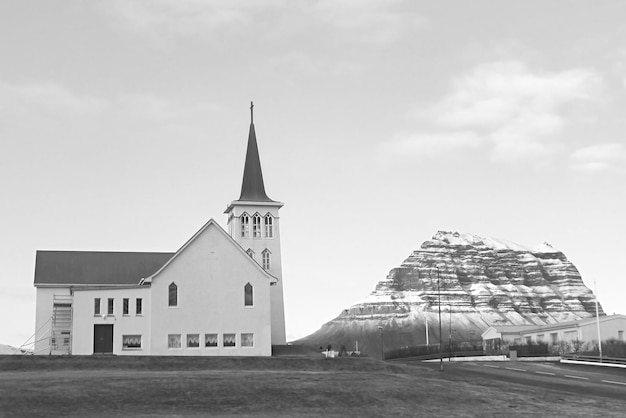 Photo monochrome image of church of grundarfjordur town with the famous kirkjufell mountain iceland