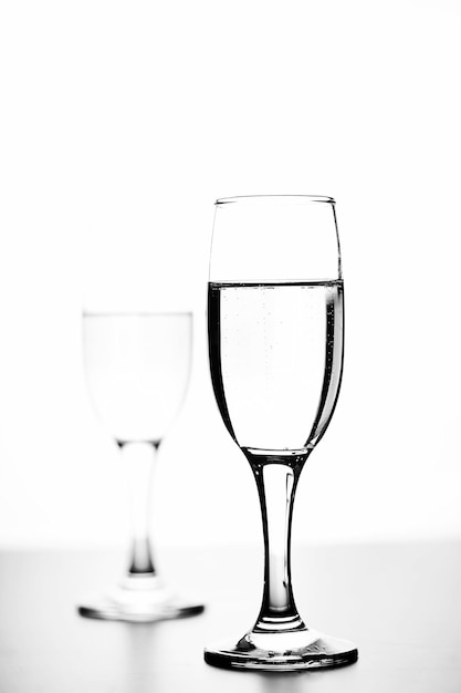 Фото Монохромное фото шампанского на белом столе на белом фоне изолировать