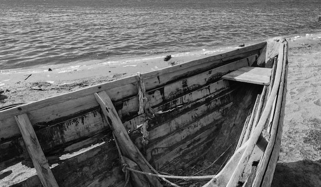Monochrome photo of an old wooden boat on the riverbank