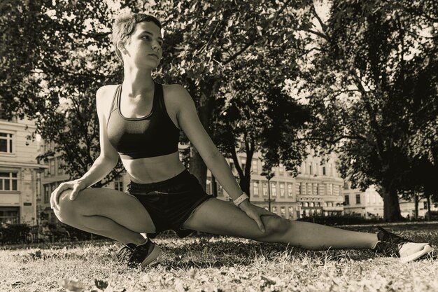 Monochrome photo of teenage girl during workout in park